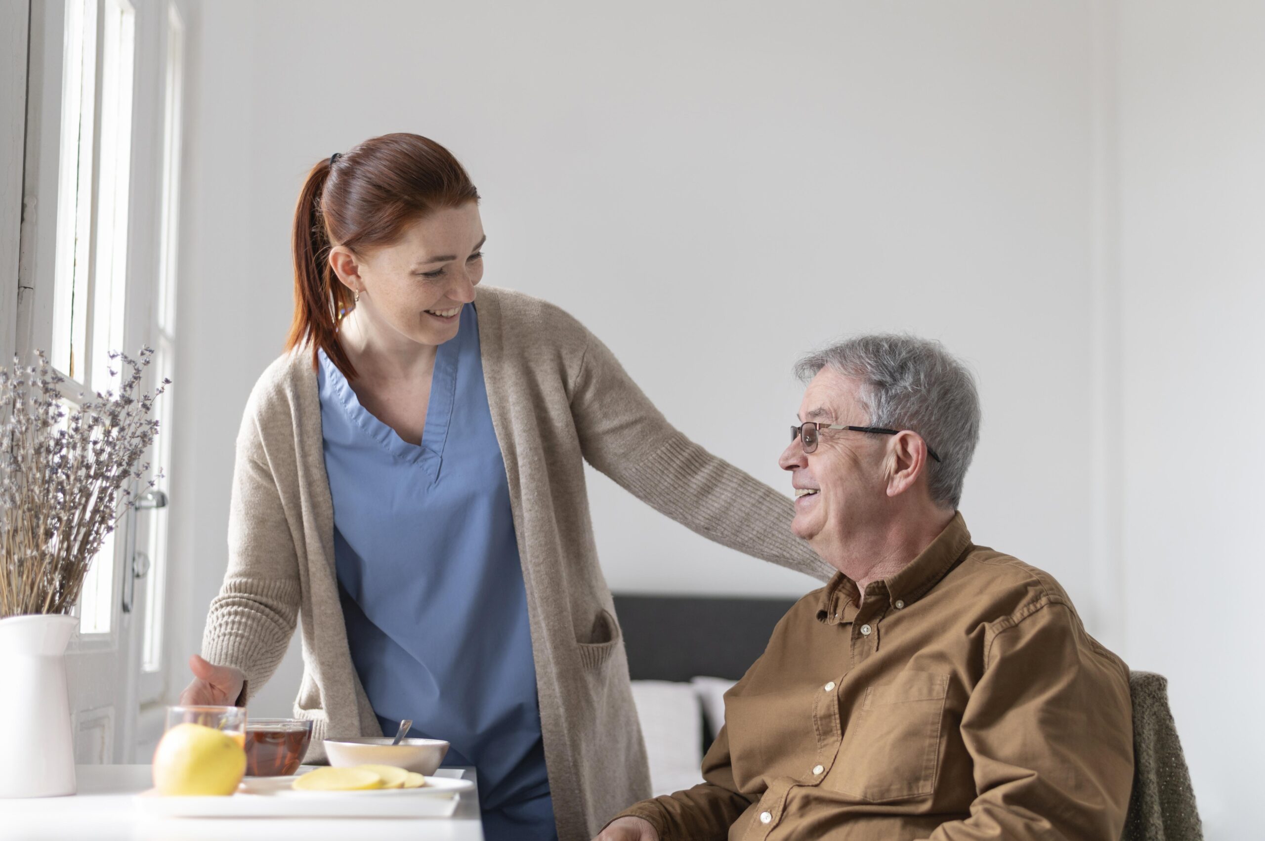 Nurse brining food to a senior male